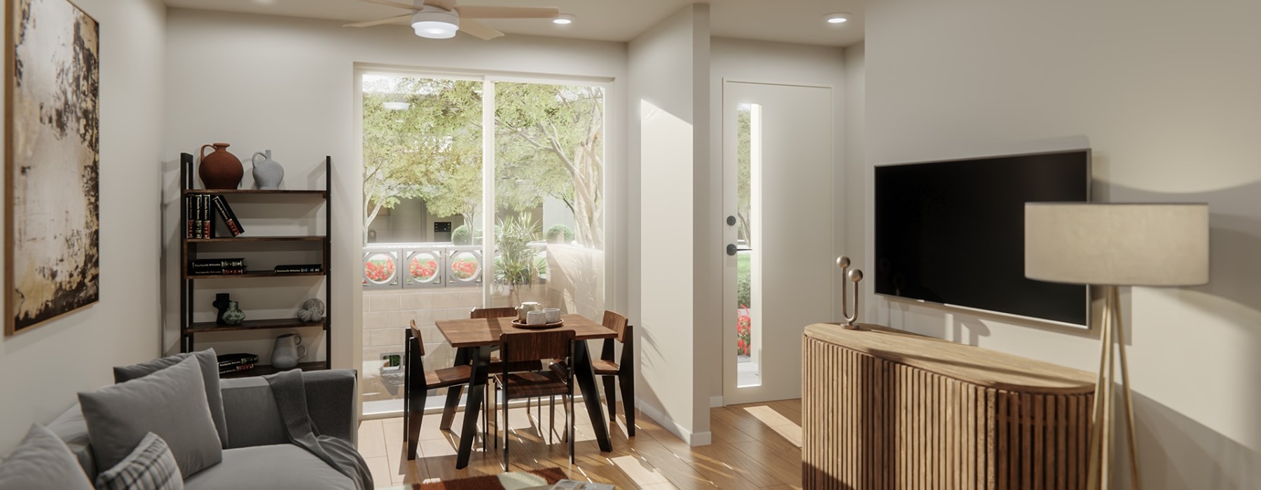 Interior view of a Sonoran Row townhome featuring an open living and dining area with natural light, modern furnishings, and direct access to a private front entry.