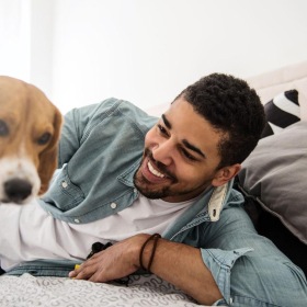 a person lying on a bed with a dog
