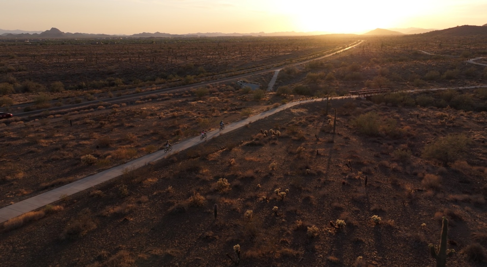 a road through a desert at dusk