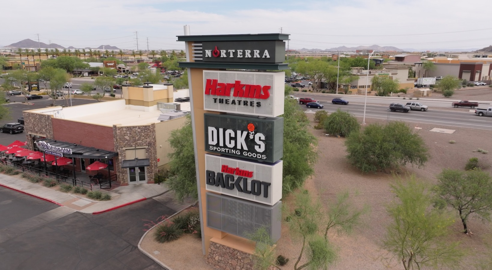aerial view of a shopping center and sign next to a street
