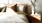a bed with a white and brown comforter